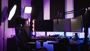 Dark streaming setup with empty chair and glowing screens